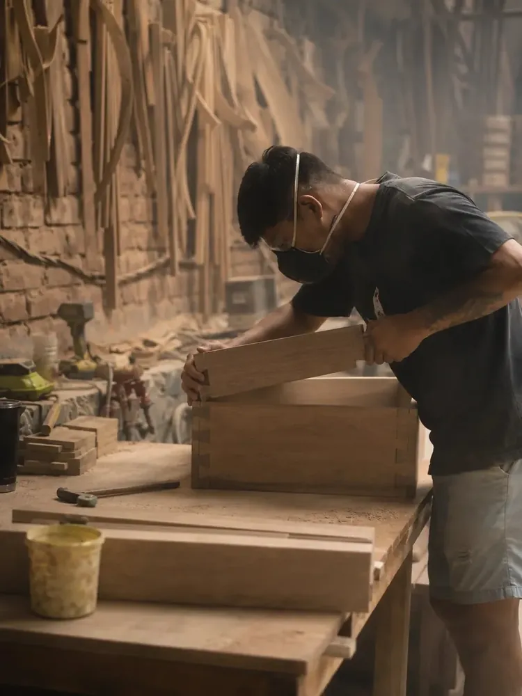 Artesano ensamblando una pieza de madera sólida, cola de milano